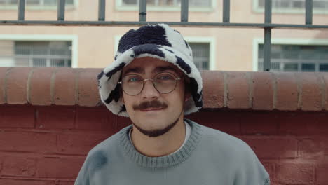 portrait of young gen z guy in trendy hat on the street