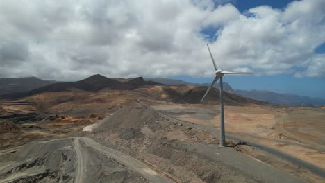 Einzelne-Windkraftanlage-Rotiert-Auf-Der-Staubigen-Wüstengebirgslandschaft,-Luftaufnahme,-Umlaufbahn-Links