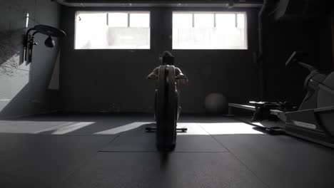 young athletic man doing exercise in the gym at the rowing machine