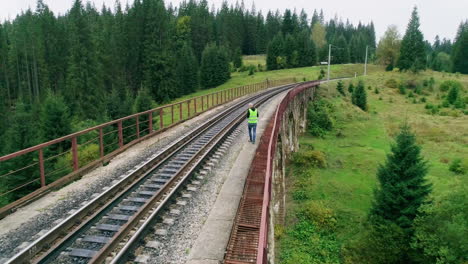 trabajador del ferrocarril en un puente de montaña