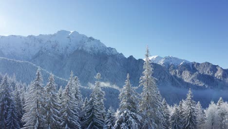 Snow-capped-Bucegi-Mountains-with-Bucsoiu-Peak-and-Muntele-Tiganesti,-clear-blue-sky