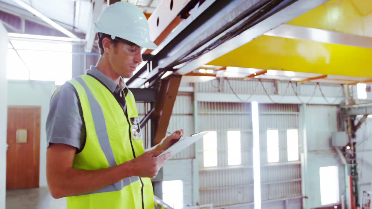 ingeniero masculino que mantiene las existencias en el taller 4k