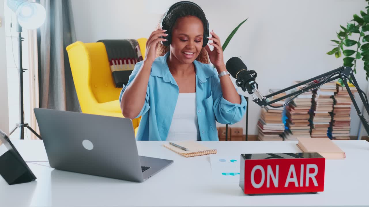 아프리카계 미국인 여성 블로거가 마이크를 걸고 캐스트를 녹음하기 시작합니다.