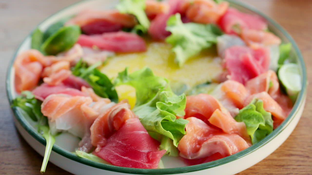 Farverig salatskål med frisk laks, tun, grønt og citrusdressing