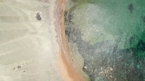 top down view of clay cliffs and shallow bay in malta, with gusty wind ripples on water