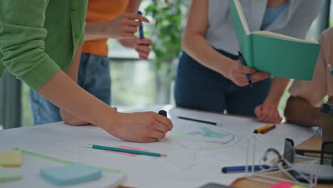 startup team drawing strategy plan at desk closeup. coworkers hands creating