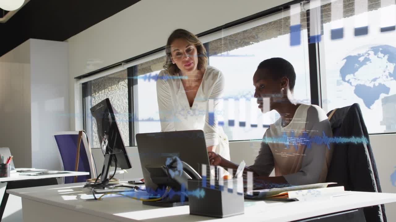 Standing woman pointing at laptop, guiding seated woman through analytics with animated charts