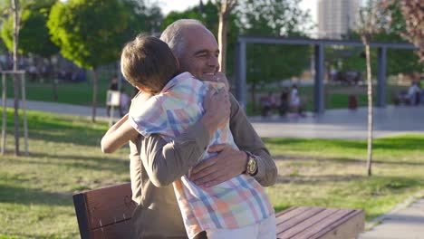 nieto abrazando a su abuelo al aire libre.