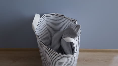 throwing dirty clothes in the laundry basket