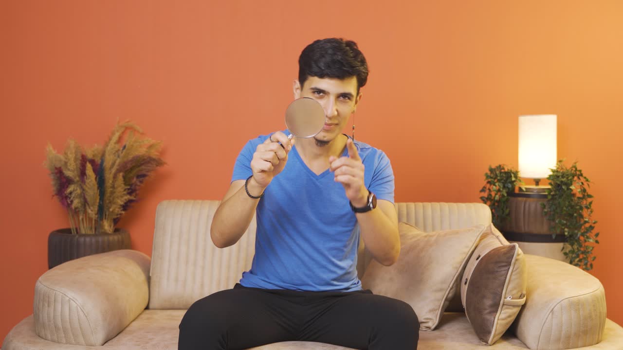 커다란 유리창으로 카메라를 보는 남자.