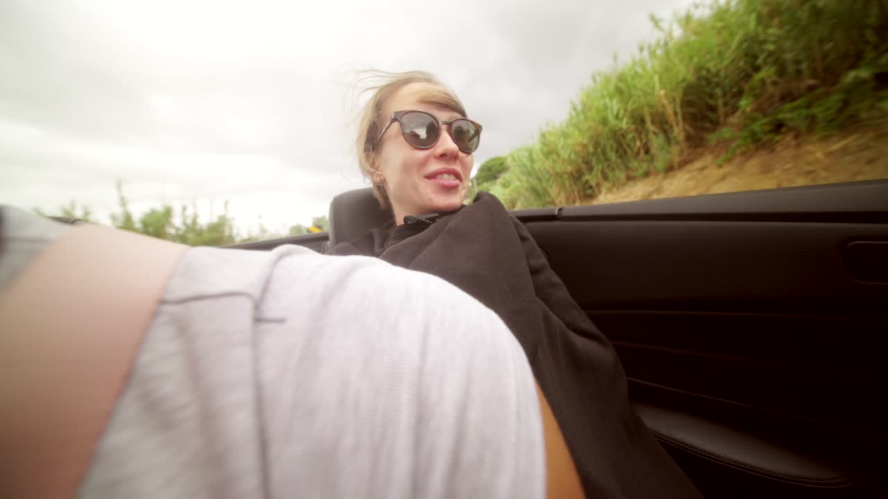 Woman enjoying a convertible ride on a road trip