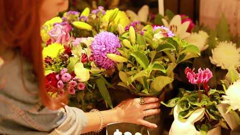 a person arranges vibrant flower bouquets in a warmly lit flower shop, creating a lively and colorful atmosphere