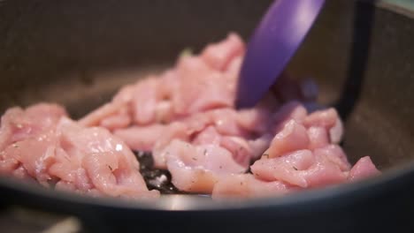 cocinar carne de pollo, asar carne de pollo en una sartén en la cocina por un cocinero italiano