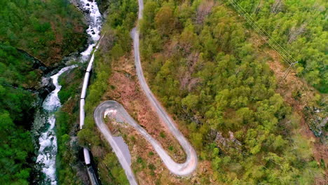 cinematic aerial drone shot flying over most scenic flam line runs past waterfalls, mountains and fjords alongside the rallar road, western norway