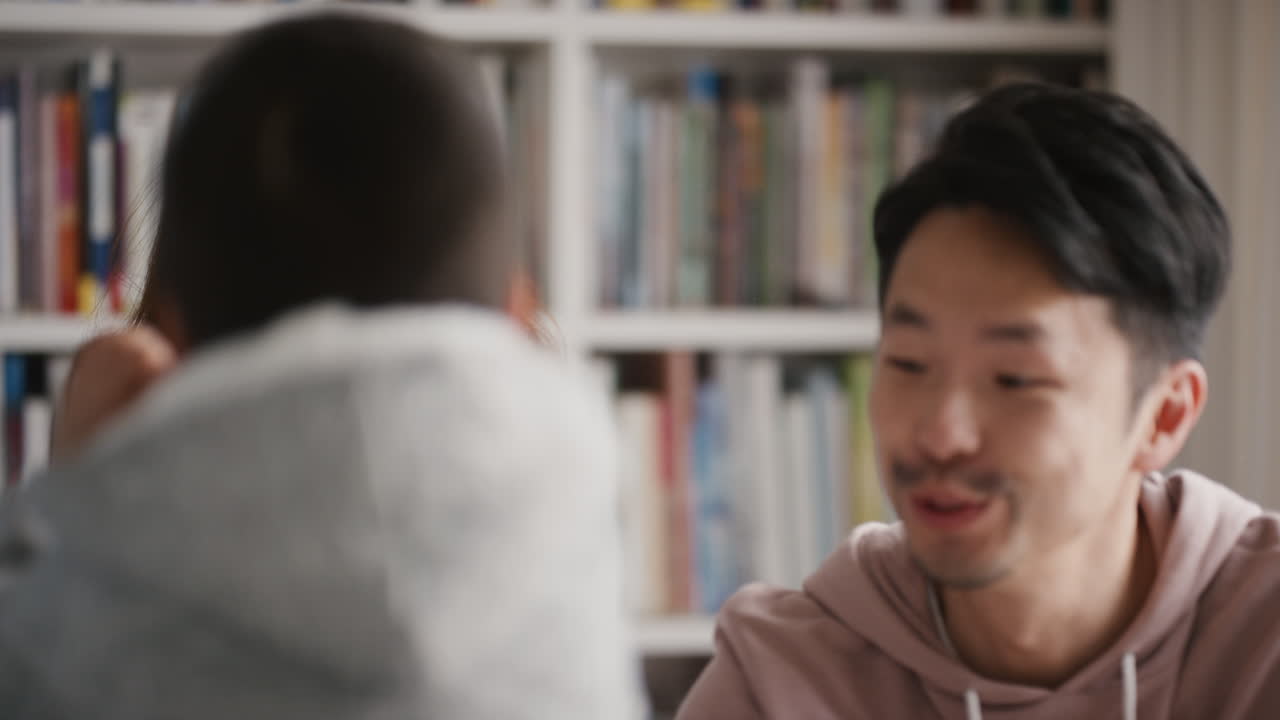 행복한 아시아 가족이 집에서 춤을 추고 즐거운 춤을 추고 함께 축하합니다. 작은 아이들이 엄마와 아빠와 함께 축하하고 흥미진진한 주말 4k 영상을 즐기고 있습니다.