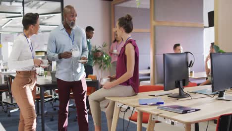 Happy-diverse-business-people-discussing-work-during-meeting-at-office