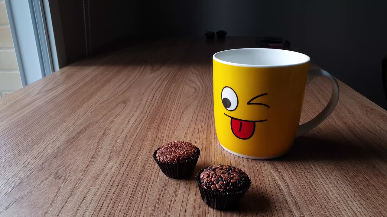 Yellow mug sticking out, tongue out, next to two brigadiers.