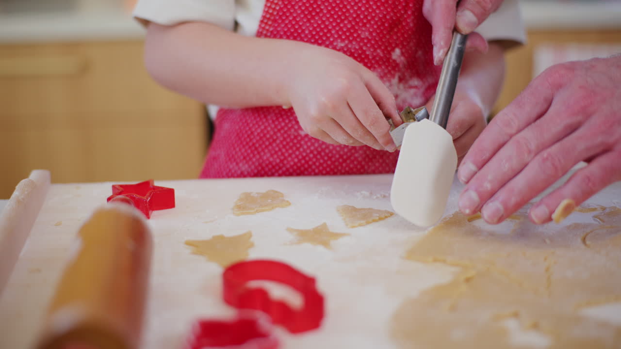 el niño y su padre preparan galletas de pan de jengibre de navidad.