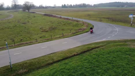 Drohnenaufnahme-Eines-Motorradfahrers,-Der-Mitten-Im-Nirgendwo-Eine-Straße-Entlangfährt