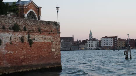 old vintage buildings of venice from moving boat during sunset