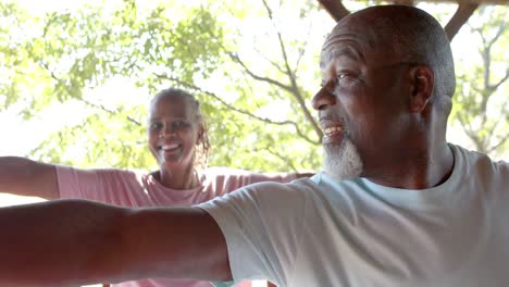 Feliz-Pareja-Afroamericana-Mayor-Practicando-Yoga-En-Una-Terraza-Soleada,-Cámara-Lenta