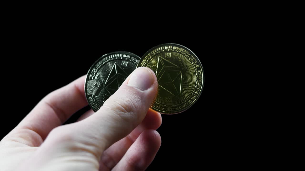 Cryptocurrency coins held against a black backdrop