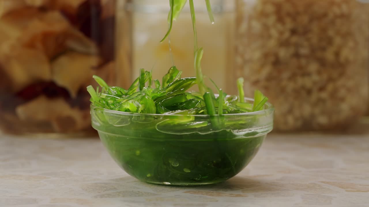 Japanese wakame chuka fermented food. Close-up on a detail of Hiyashi Wakame Chuka or seaweed salad or seaweed with sesame seeds on a plate. Top view. Seafood background. Health concept.