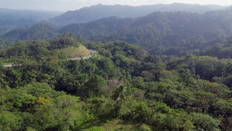 Breathtaking-Flyover-Drone-Shot-of-lush,-tropical-jungles,-hills,-and-winding,-mountainside-roads-in-Catanduanes,-Philippines