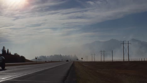 Carretera-Con-Humo-De-Fuego-Cerca-De-Las-Montañas