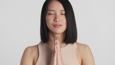 asian woman showing namaste gesture on camera.