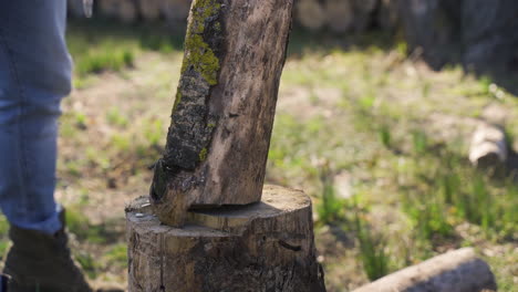 Close-up-view-of-unrecognizable-man-chopping-firewood-with-an-ax-outside-a-country-house