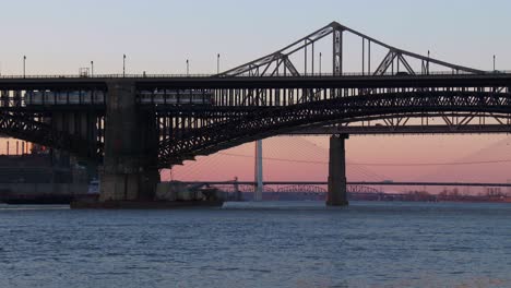 small barge travels under a bridge along the mississippi river near st louis 1