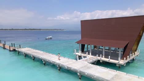 Weibliche-Person,-Die-Auf-Einem-Holzsteg-Auf-Der-Insel-Gili-Meno-In-Lombok-Spazieren-Geht