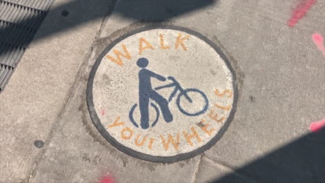 aviso de bicicleta en la acera para caminar sobre la tapa de alcantarilla