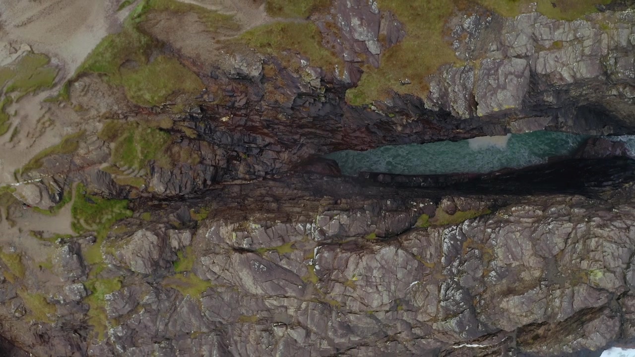 Top-down ascending aerial of Hell’s Hole cliff formations in Donegal.