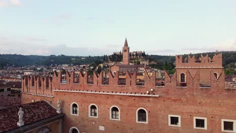 basilica di santa anastasia bell tower rises behind walls of palazzo del podestà in verona