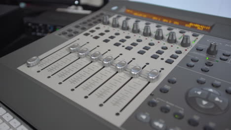 dolly above looking down on audio mixer as dials move on their own