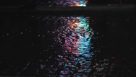 neon city street lights reflected in a city street rain puddle