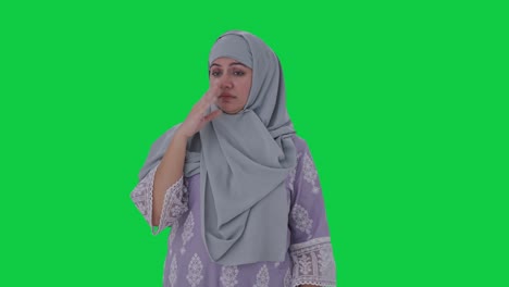 mujer musulmana perturbada disgustada por el mal olor pantalla verde
