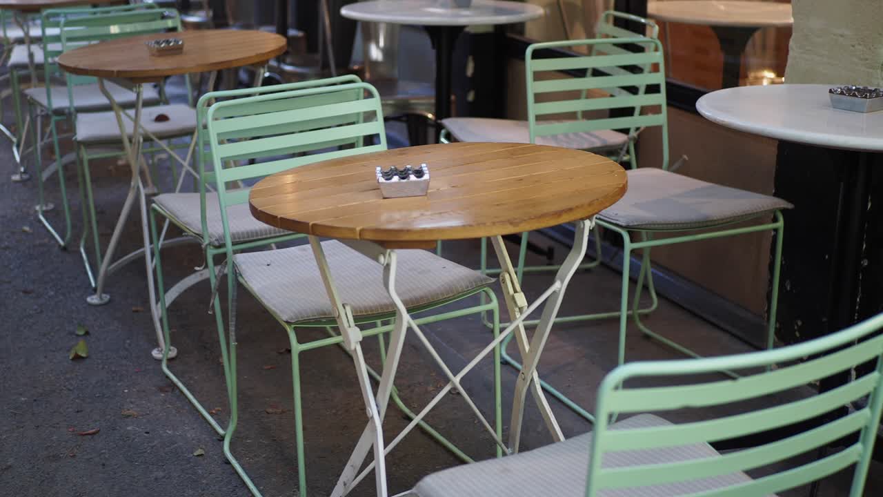 Empty tables and chairs on a sidewalk cafe