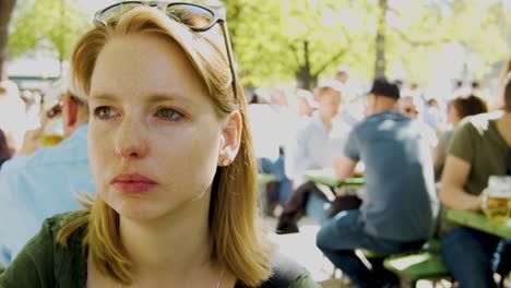 woman sitting in crowded beer garden