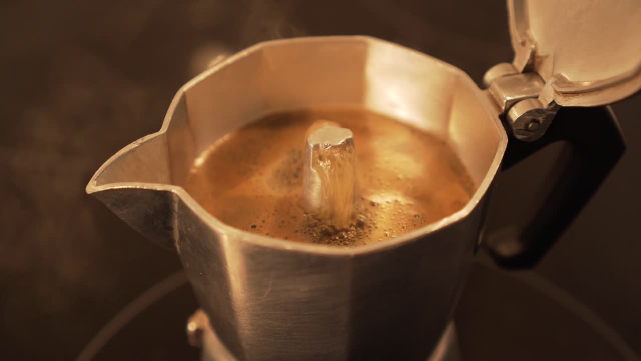 Detail of making espresso coffee in moka pot - bubbling at the end, closeup
