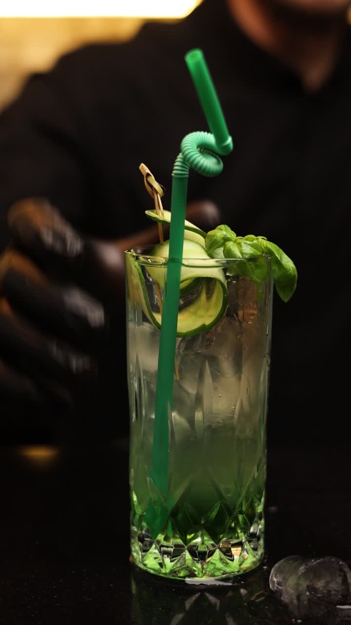 Bartender preparing a refreshing cucumber and basil cocktail