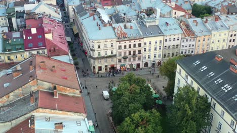 aerial view of people walking the streets of lviv ukraine during sunset in the summer of 2021 surrounded by old european style buildings