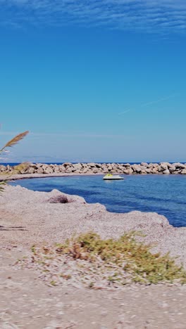 costa tranquila con muelle rocoso y agua azul clara en un día soleado