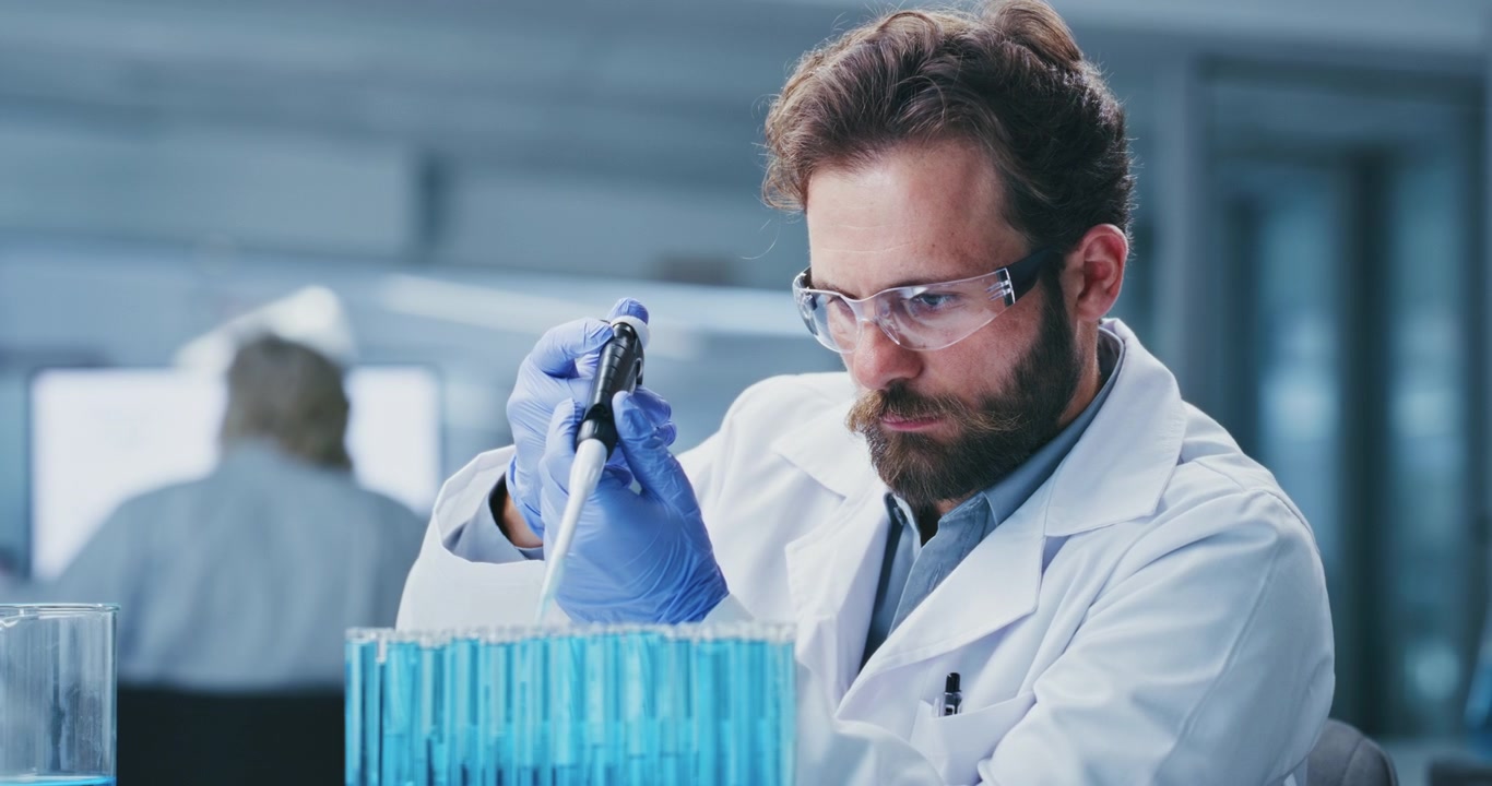 Scienziato che usa una pipetta per trasferire liquido in laboratorio