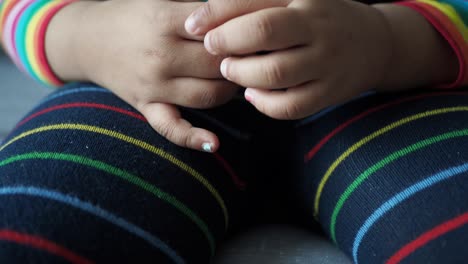 las manos del niño en pijama a rayas