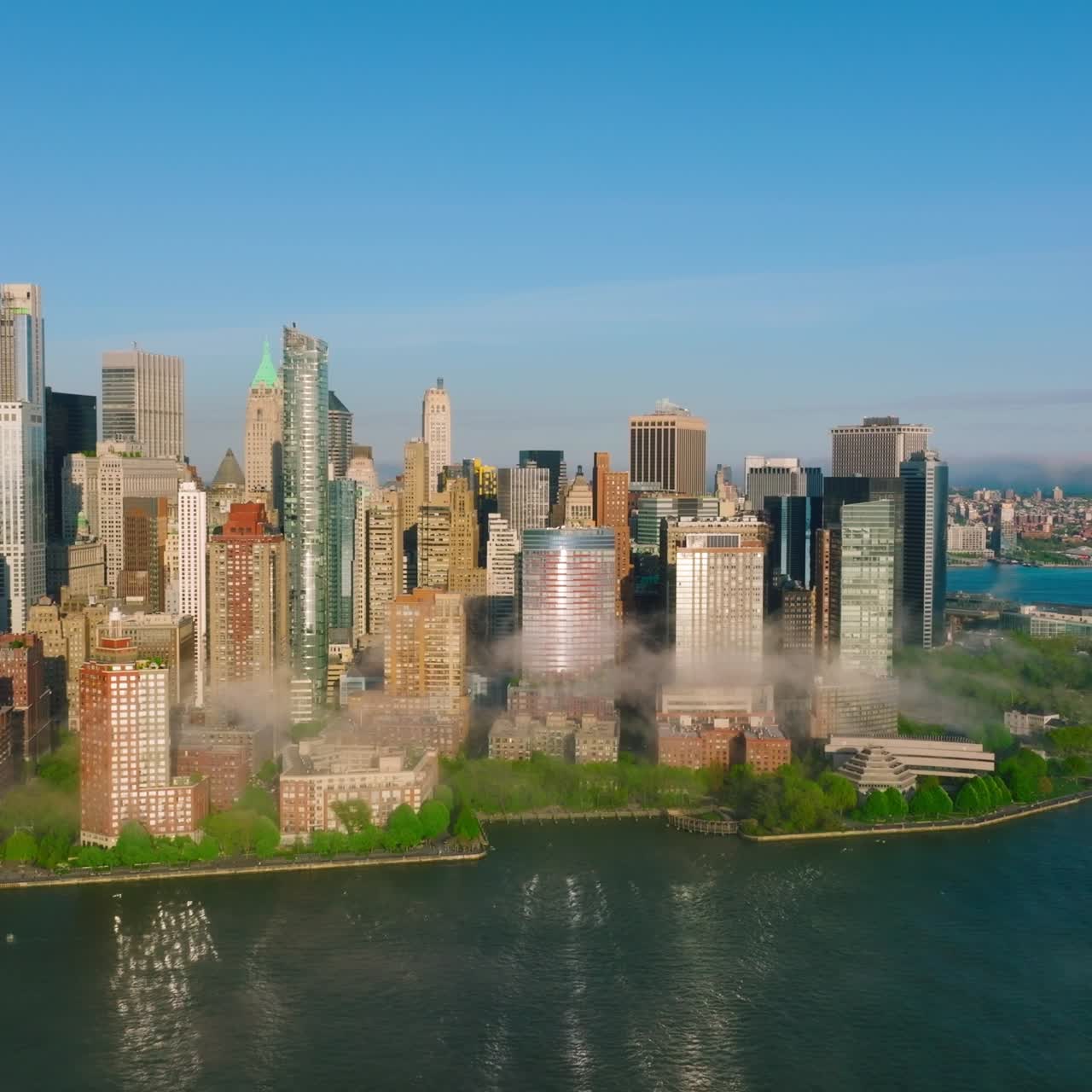 Stunning Manhattan island with shiny skyscrapers reflecting in the water. Daytime perspective on New York from river