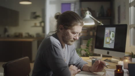 man writing down ideas at home workplace