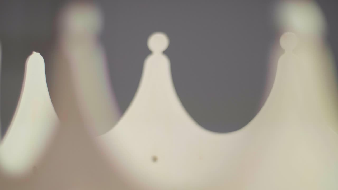 플라스틱으로 만든 받침대에서 들쭉날쭉한 회전하는 베이지색 크라운 봉우리를 닫습니다.